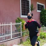 photo of woman jogging beside building during daytime