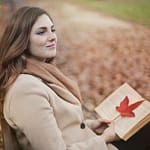 young woman with book in autumn park