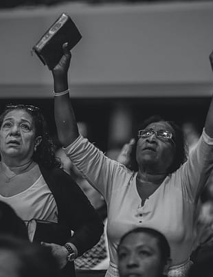 grayscale photography of people worshiping